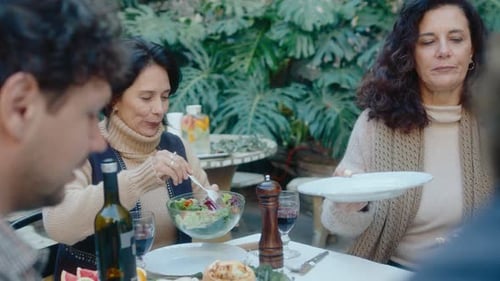Companhia de amigos desfrutando de comida em um jantar ao ar livre