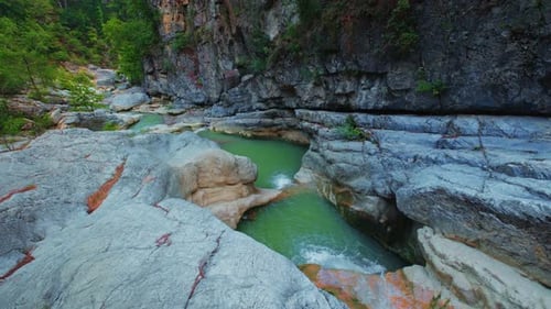 Serene forest creek with rocky waterfall and clear turquoise water nature scene