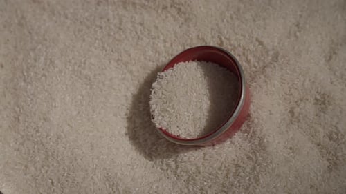 vista cercana de los granos de arroz blanco con una cuchara de metal apoyada en la parte superior