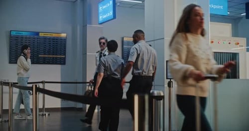 Airline Captain and Two Stewardesses Walking for Commercial Flight in Crowded Airport Terminal
