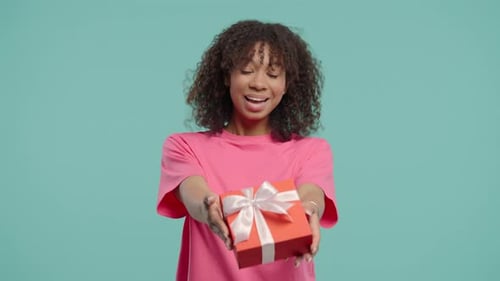 Smiling Woman Presents a Birthday Gift in Studio