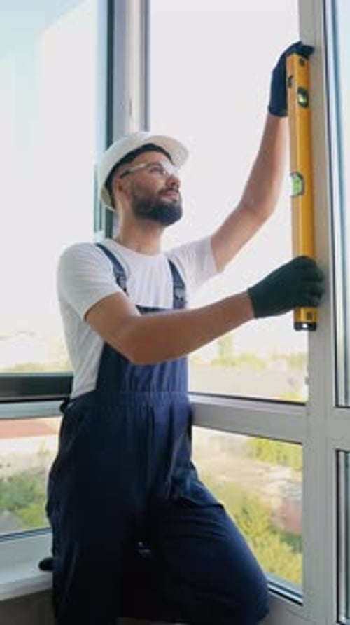 Worker Using Level to Ensure Precise Window Installation