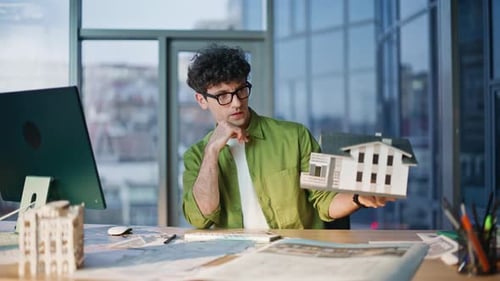 Construction Designer Thinking Project Holding House Model at Office Closeup