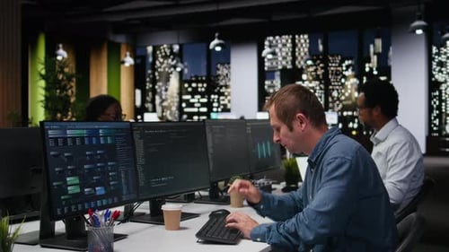 People working at computers in urban office at night