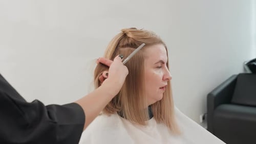 Woman getting her shoulder length hair styled indoors