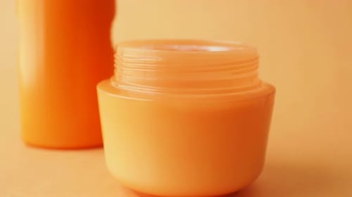 Close Up of Sunscreen Cream Ion Orange Color Background