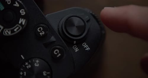 Close up static shot of finger turning off camera. Top view