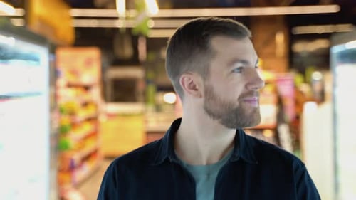 A Man Walks at Grocery Supermarket and Choosing the Right Product