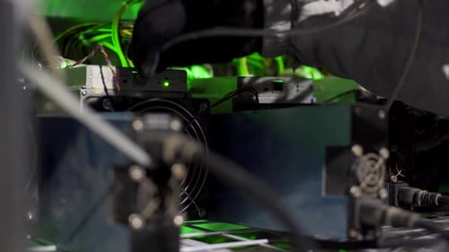 Cryptocurrency Mining Equipment Service on Bitcoin Farm Technician Inserts Ethernet Cable Connector