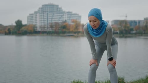Woman in Headscarf Resting After Exercise in Park