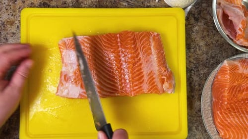 Preparing salmon fish fillets with a knife for further cooking. Top view.