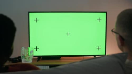 Mates Chatting in front of Green Screen TV Set in Modern Apartment