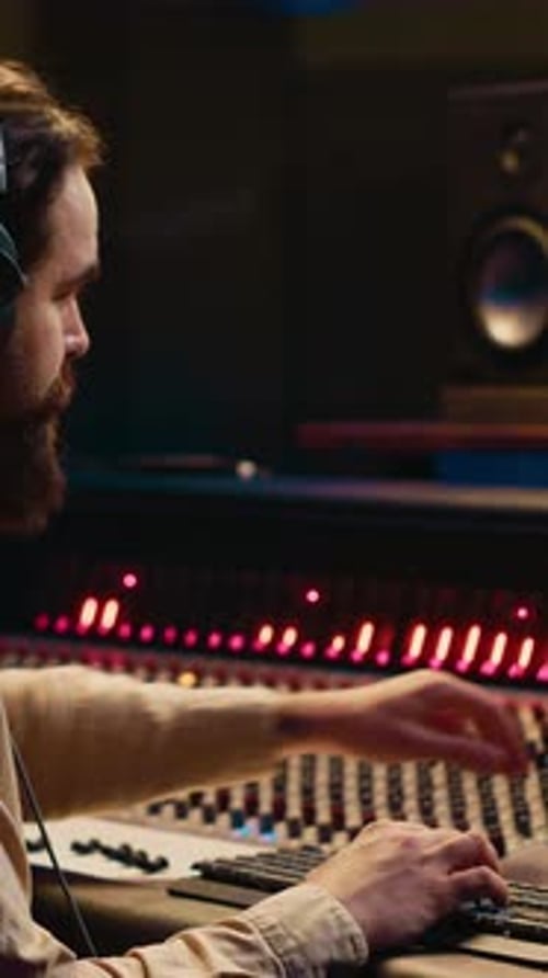 Man Working at Audio Mixer in Recording Studio