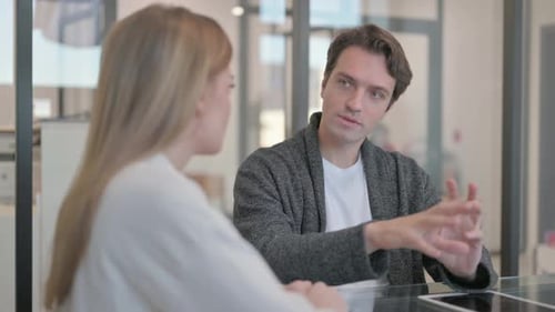 Jeune homme parlant avec une collègue