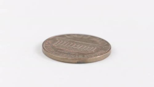 Penny Coin Laid Flat On White Table. Isolated Object, Spinning