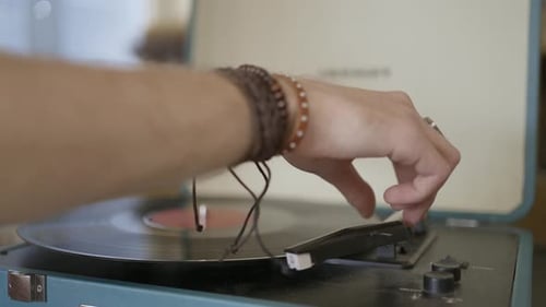 Hand Placing Needle on a Vinyl Record