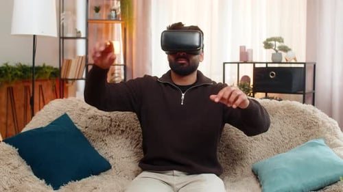 Man wearing VR headset sitting on couch