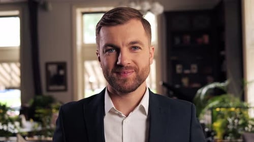 Empresário profissional positivo sorridente olhando para a câmera no restaurante