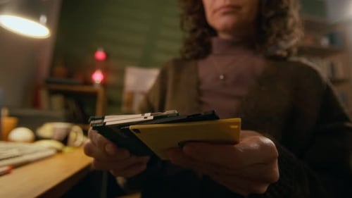 Anonyme Frau aus den 90ern inspiziert und markiert einen Stapel von Disketten