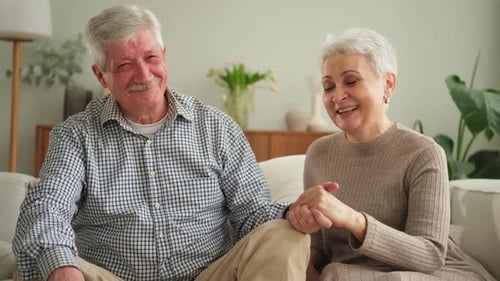 Loving Senior Couple Holding Hands and Smiling