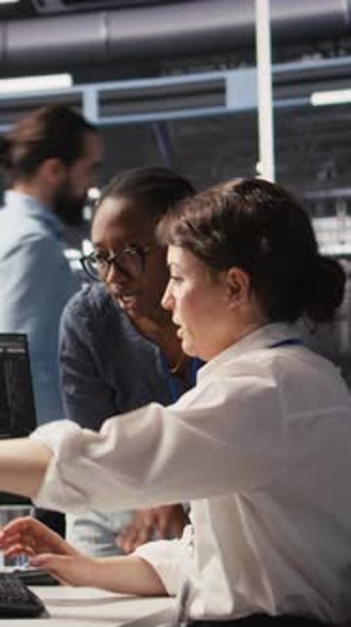 Vertical Video Data Center Technicians Adjusting Blade Server Hardware Powering AI