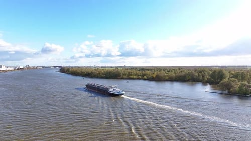 Vessel navigates the river, creating gentle ripples on the water surface