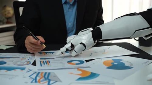 Man and Robot Arm Reviewing Charts in Office