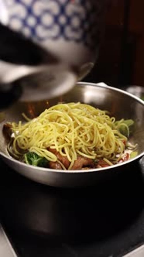 Noodles with vegetables cooking in a wok