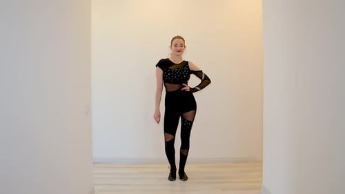 Woman Dancing in Black Dance Costume in White Room
