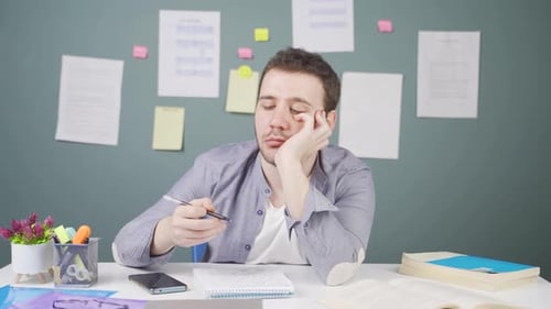 Tired Student Studying at His Desk