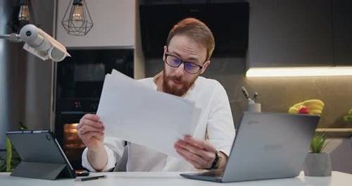 Man Working from Home on Laptop and Tablet