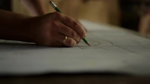 Des mains d'artistes non reconnues préparent le dessin d'un produit en bois dans un atelier de menuiserie