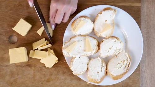 Woman preparing tasty appetizer with cheese and bread