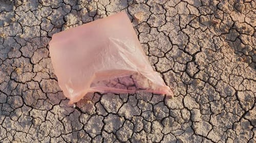 Una bolsa de plástico vuela en tierra seca: desastre ambiental