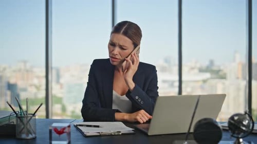 Concerned Woman Talking on Phone in Office