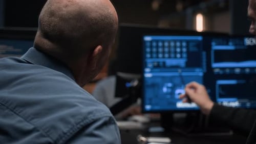 Especialistas em segurança cibernética analisando dados em telas de computador no escritório