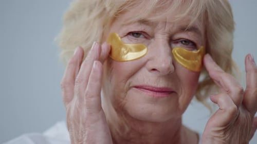 Woman Applying Golden Eye Patches for Beauty