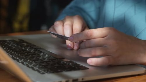 Woman is Making Payments Online with Her Credit Card and Laptop