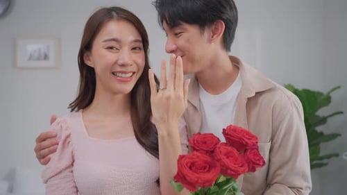 Engaged Couple Embrace Holding Red Roses