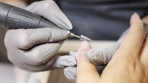 Manicurist Filing Fingernail with Electric File