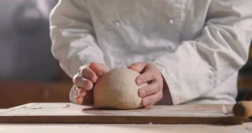Close up of a baker kneading with his hands to prepare the bread to put in the oven. Concept of: a