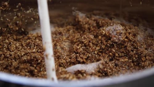 Foto aproximada de mexer a cevada maltada no processo de fabricação de cerveja