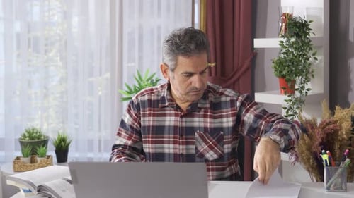 Man with work stress in home office is overwhelmed and worried.