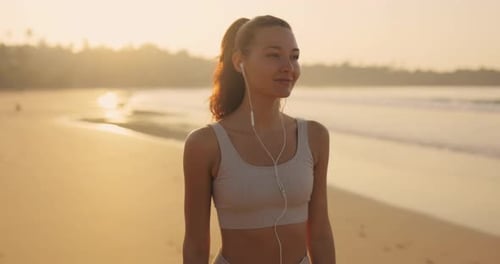 Female Runner Before Jogging With Earphones During Outdoor Workout on the Beach in Slow Motion