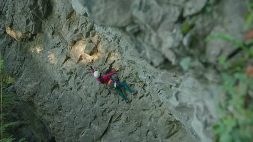Young Active Fit Muscular Girl Training Outside Climbing Stone Mountain Rock Using Ropes for Safety
