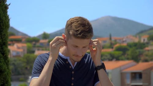 Man putting in his ear phones in Collioure, France.