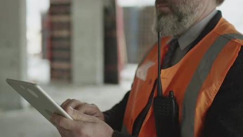 Erwachsener Vorarbeiter überprüft die Arbeit auf der Baustelle