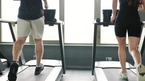 Back View Unrecognizable Fit Man and Woman Engaging in Cardio Workout Routine Treadmill
