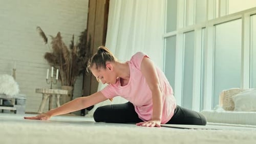 Woman Doing Yoga Split Stretch Indoors