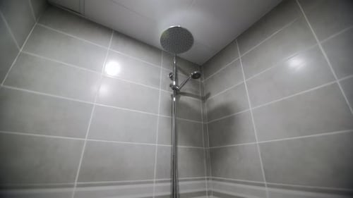 Duschkabine, Toilettenschüssel und Waschbecken im beleuchteten Badezimmer